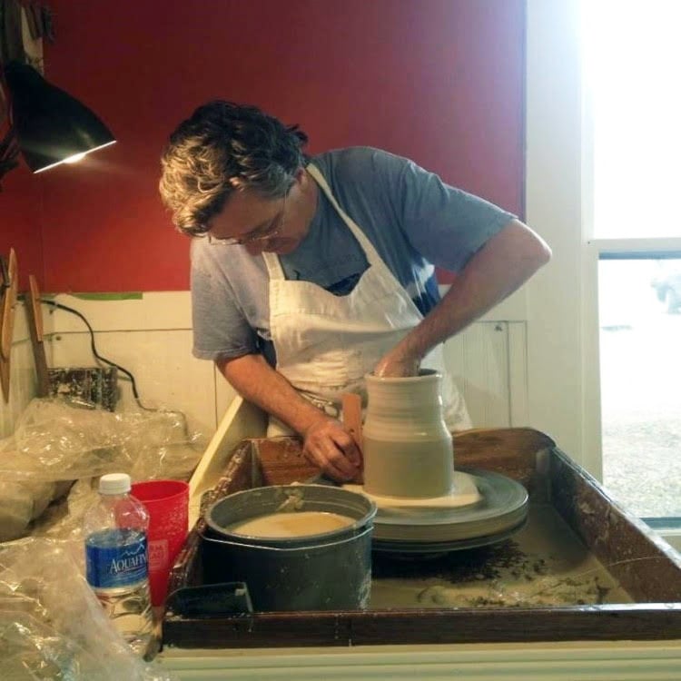  Kenneth Neilsen master ptter in Cary North Carolina shaping handmade pottery on a wheel